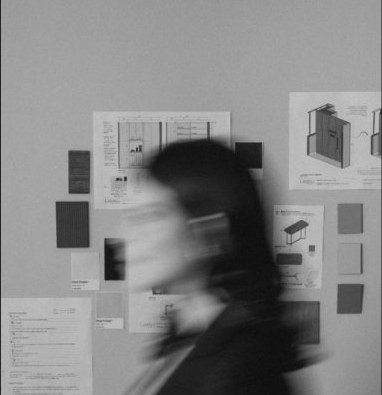 Blurred person walking past planning boards